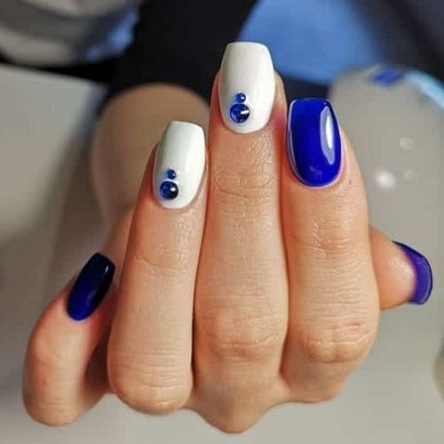 short royal blue nails with white accents and rhinestones