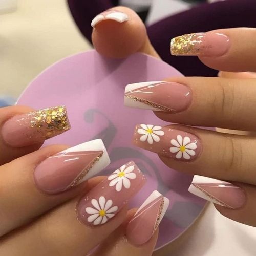 gel nails with french tips and daisy flowers on beige background