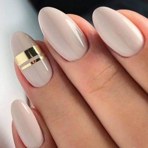 light beige round acrylic nails with simple minimalistic gold strip design