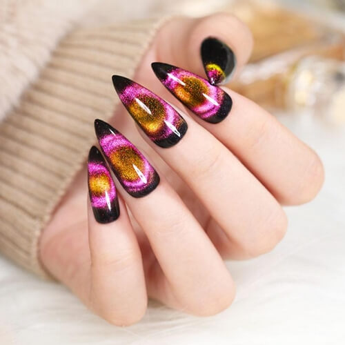 Medium length stiletto gothic nails with purple, black and gold glitter design elements